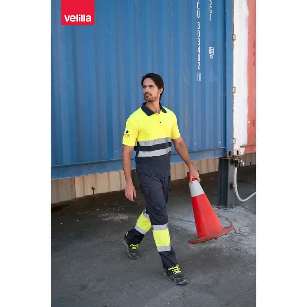 Man i reflexkläder och trafikvimpel framför blå container, arbetsmiljö.