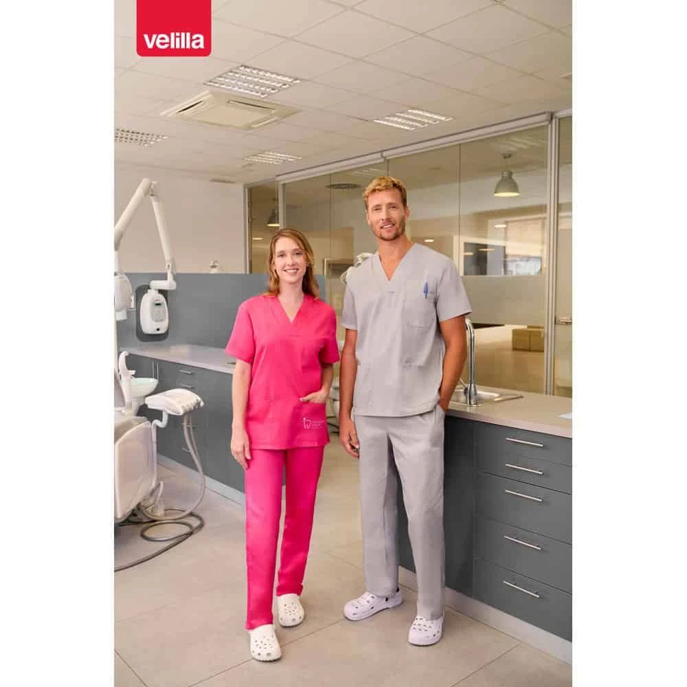 Två personer i VL ILLAPA twilltunika i klinikmiljö, leende och professionella.