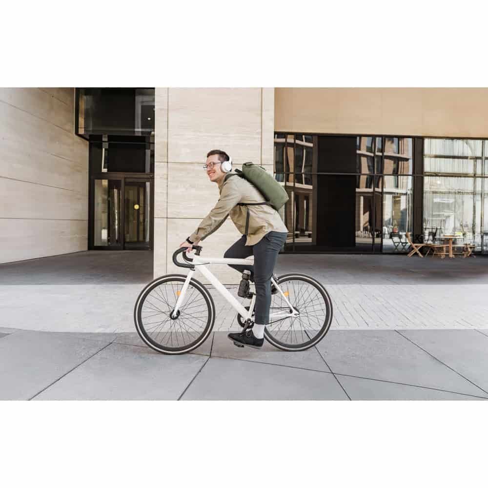 Man med Atenas 600D laptopryggsäck cyklar på stadsgata.