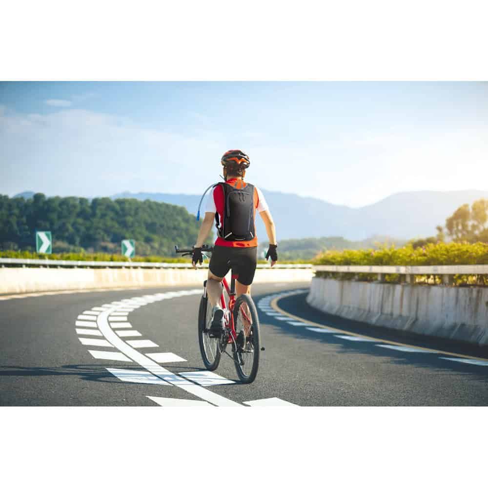 Cyklist med Mounti 420D sportryggsäck och 2L vattentank på landsväg.