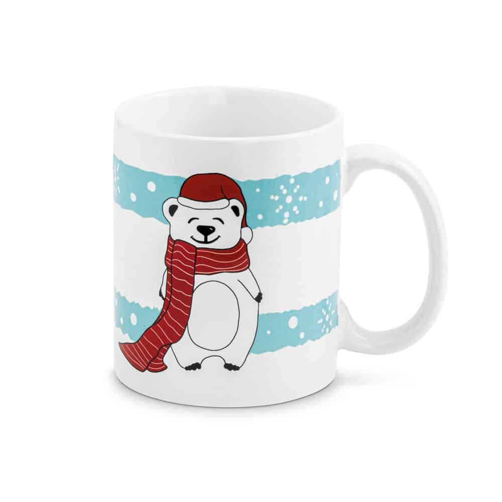 Vit mugg med isbjörn i mössa och halsduk, snöiga bakgrundsstrimmor.