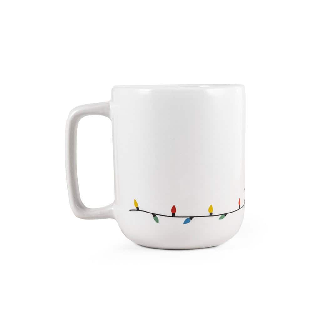 Vit julmugg med ren och julbelysning i färgglada ljus.